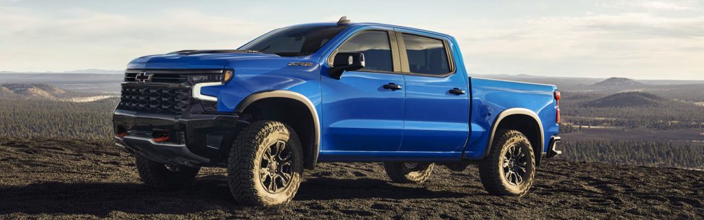 A blue Chevrolet Silverado truck parked on rugged terrain.