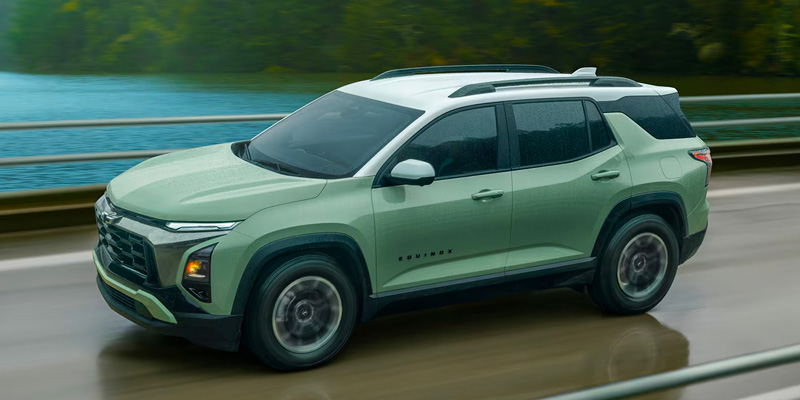 Green Chevrolet Equinox SUV driving on a wet road showcasing its modern exterior design and styling.